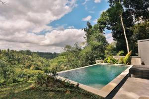 a swimming pool with a view of a forest at Bali Ubud Villa View in Ubud