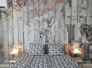 Schlafzimmer mit einem Bett mit Wandzeichnung in der Unterkunft Hegyalja Apartman in Miskolc