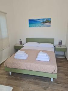 ein Schlafzimmer mit einem Bett mit Handtüchern darauf in der Unterkunft Scauri Rooms B&B in Minturno