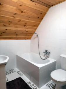 a bathroom with a white tub and a toilet at AŻ POD LAS in Zbiczno