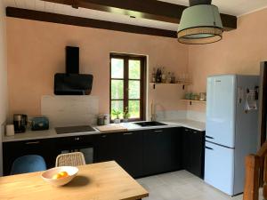 a kitchen with black cabinets and a white refrigerator at AŻ POD LAS in Zbiczno