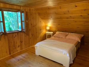 ein Schlafzimmer mit einem Bett in einer Holzhütte in der Unterkunft AŻ POD LAS in Zbiczno
