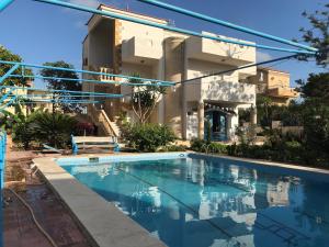 a swimming pool in front of a building at Blue family villa with large private pool in El-Shaikh Mabrouk