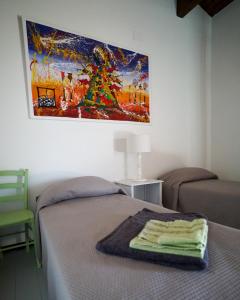 een slaapkamer met een bed en een schilderij aan de muur bij bnbthekey 1,2,3 in Olmedo