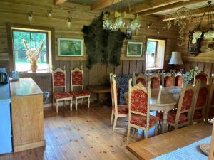 ein Esszimmer mit einem Tisch und Stühlen in der Unterkunft Nature Resort Stirnelė in Kraujeliai