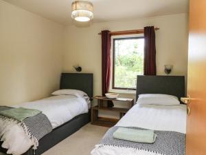 dwa łóżka w pokoju z oknem w obiekcie The Shieling w mieście Newtonmore