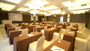 a conference room with tables and chairs and a screen at Sareeviengping Hotel Chiangmai in Chiang Mai