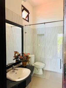 a bathroom with a sink and a toilet and a glass shower at Ngan Phu Villa in Hoi An