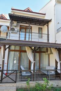 a house with a balcony with chairs and a table at VİLLA ALP'S TRİPLEX LAGOON HAVUZ OLANAĞI SUNAN in Belek