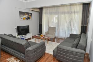a living room with two couches and a television at VİLLA ALP'S TRİPLEX LAGOON HAVUZ OLANAĞI SUNAN in Belek