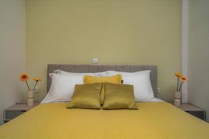 a bed with two yellow pillows on top of it at Andy's & Hari's Elegant Town Studios in Zakynthos Town