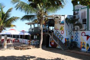 a building on the beach with a staircase and palm trees at Pescador Villas in Inhambane