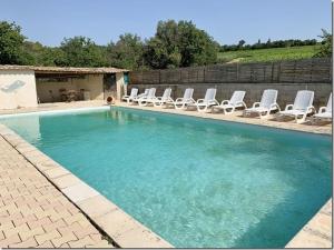 a swimming pool with lounge chairs and a group at Gîtes Meynard et Lorie in Vinsobres