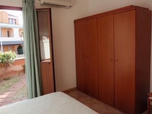 een slaapkamer met een houten kast en een raam bij Borgo Saraceno Mirto 5 in San Pasquale
