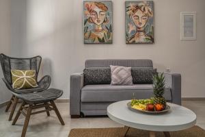 a living room with a couch and a table with a bowl of fruit at Andy's & Hari's Elegant Town Studios in Zakynthos Town