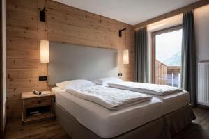a bedroom with a large bed and a window at Residence Cesa Sassela in Ortisei +50 photos