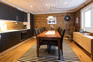 cocina con mesa de madera y armarios negros en Lake View Apartment 4 bedrooms and 2 bathrooms, en Sykkylven
