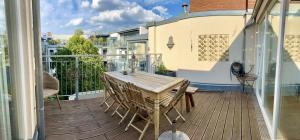 terraza de madera con mesa y sillas en el balcón en Kreuzberger Szene Penthouse, en Berlín