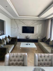 sala de estar con sofás y TV de pantalla plana. en Luxueux appartement Ritz Carlton Marina Smir, en Sania Torres