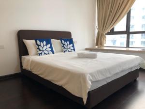a bedroom with a large bed with blue and white pillows at R&F Princess Cove by StayHere - 3BR in Johor Bahru