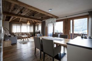 a dining room and living room with a table and chairs at Residence Cesa Sassela in Ortisei