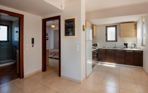 a kitchen with brown cabinets and a white refrigerator at Blue Wave Villa - road view in Gennadi +14 photos