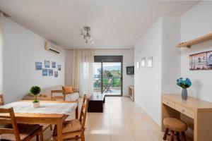 a dining room and living room with a table and chairs at Blue Wave Villa - road view in Gennadi