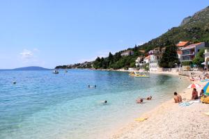 a group of people in the water at a beach at Apartments by the sea Brist, Makarska - 13011 in Podaca