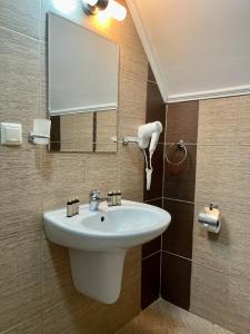 y baño con lavabo blanco y espejo. en Villa Orange en Sozopol