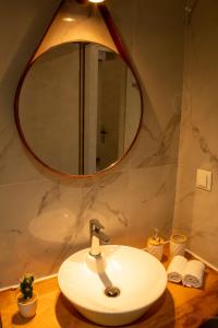 een badkamer met een wastafel en een spiegel bij Tabak home Sea side apartment in Chania +23 foto's