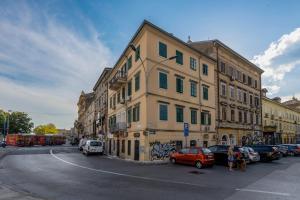 un edificio al lado de una calle con coches aparcados en Bella Vita Apartments en Rijeka