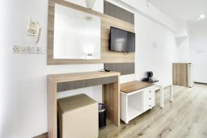 a living room with a desk and a tv on a wall at Barbara Hotel Apts in Ayia Napa