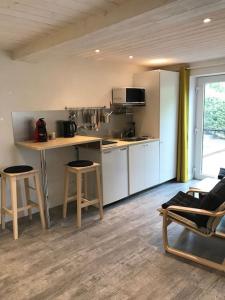een keuken met een aanrecht en krukken in een kamer bij Studio Au jardin fleuri in Verviers