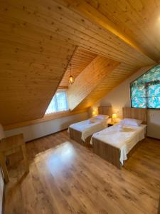 um quarto no sótão com 2 camas e um tecto de madeira em Lanchvali Inn em Mestia