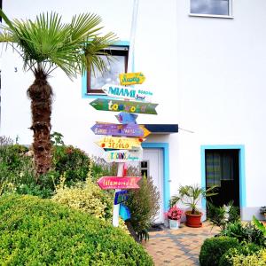 a street sign with many signs in front of a house at Emyda' s Tropical Home at Goldsteig trail in Wiesau