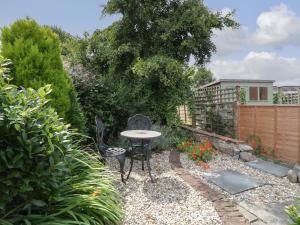 a patio with a table and chairs in a garden at 7 Severn Terrace in Watchet