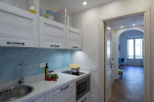 a kitchen with white cabinets and a sink at AMORE RENTALS - Casa Volte Alte in Positano