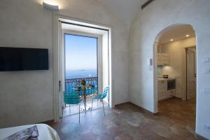 a bedroom with a balcony with a view of the ocean at AMORE RENTALS - Casa Volte Alte in Positano