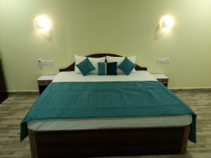 a bedroom with a large bed with blue pillows at Casa de joana deluxe in Calangute