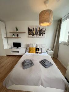 1 dormitorio con 1 cama blanca grande y TV en Ferienwohnung AllgäuSchatz Kempten, en Kempten
