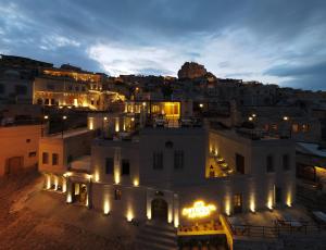 uma vista para um edifício à noite com luzes em Kappadoks Cave Hotel em Üçhisar