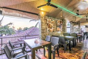 a restaurant with tables and chairs and a wall with a mural at FabExpress Victoria With Pool, Baga Beach in Baga