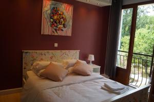 sypialnia z dużym łóżkiem i oknem w obiekcie La Maison des Eaux w mieście Saint-Jean-de-Thurac