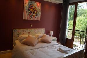 Un dormitorio con una cama grande con ventana. en La Maison des Eaux, en Saint-Jean-de-Thurac