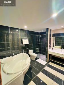 a bathroom with a tub and a toilet and a sink at HANZ Premium Mai Vy Hotel in Tây Ninh