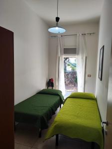 two green beds in a room with a window at Villa Francesca in Porto Cesareo