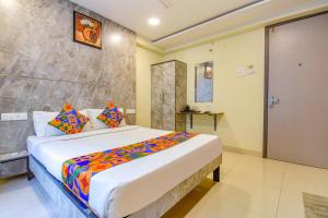 a bedroom with a large bed in a room at FabHotel Gargi Inn in Pune