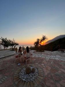 two women sitting at a table watching the sunset at Rahoni Park & Suites in Dhërmi