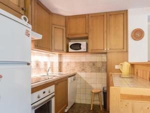 a small kitchen with wooden cabinets and a sink at Appartement Saint-Chaffrey , 4 pièces, 6 personnes - FR-1-330E-17 in Serre Chevalier