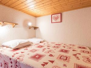 a bedroom with a bed with a blanket with a heart picture at Appartement Saint-Chaffrey , 4 pièces, 6 personnes - FR-1-330E-17 in Serre Chevalier